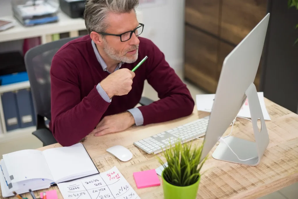 Photo d'un artisan consultant plusieurs devis de création de site internet sur un bureau, à Brignoles.