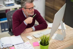 Photo d'un artisan consultant plusieurs devis de création de site internet sur un bureau, à Brignoles.
